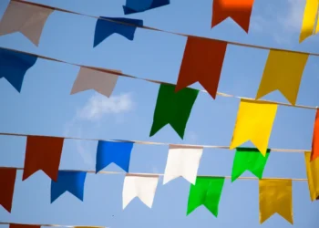 Bandeirinhas coloridas decorando o céu azul durante festa junina