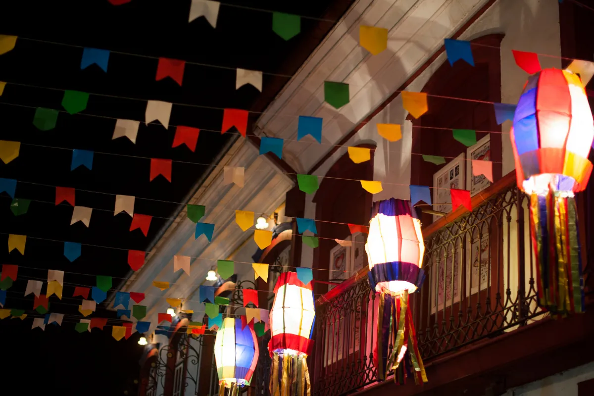 Fachada decorada com lanternas coloridas e bandeirinhas típicas de festa junina à noite