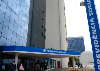 Fachada do INSS com placa e pessoas entrando