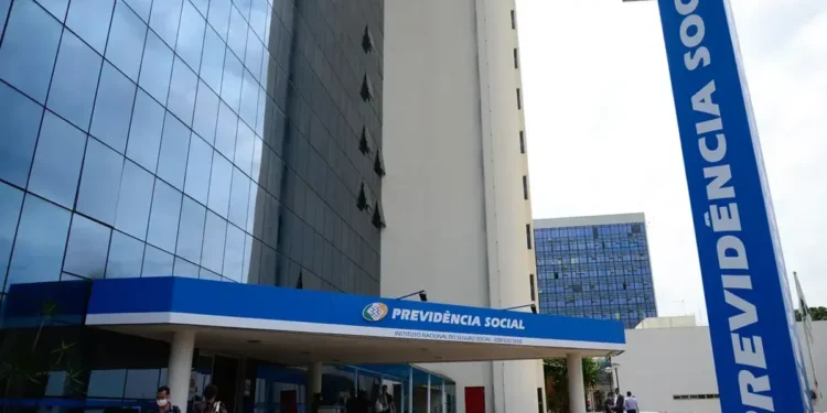 Fachada do INSS com placa e pessoas entrando