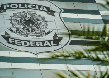 Fachada da sede da Polícia Federal com brasão em destaque.