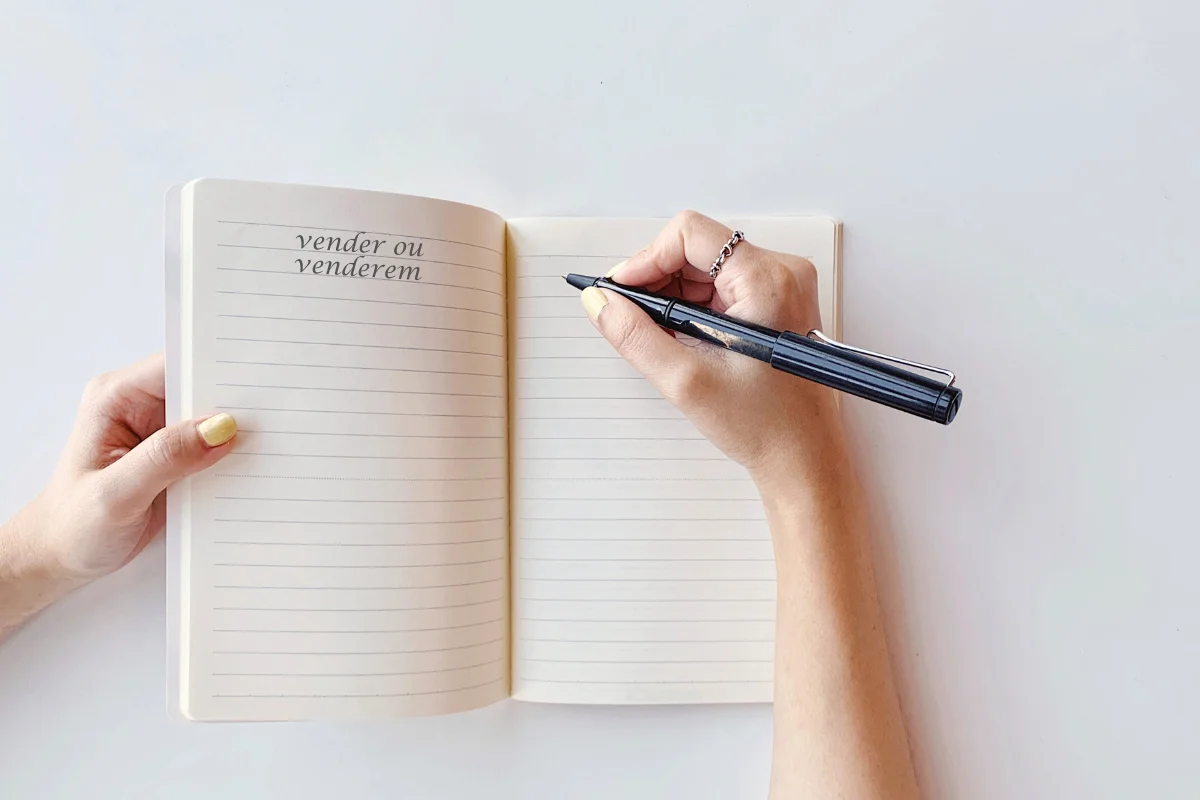 Pessoa escrevendo em caderno a dúvida 