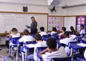 Professora ministra aula de inglês para turma do ensino fundamental.