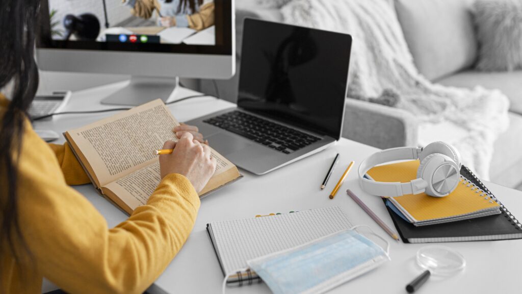 Estudante faz anotações enquanto participa de curso online gratuito