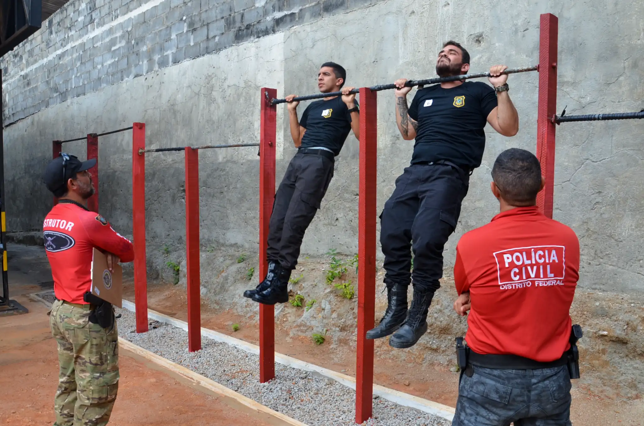 Agentes da Polícia Civil realizando barra fixa em teste físico.