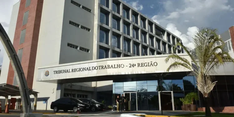 Fachada do Tribunal Regional do Trabalho da 24ª Região, mostrando o prédio e os carros estacionados na entrada, simbolizando a anulação do Concurso do TRT-MS
