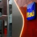 Fachada moderna de agência Itaú com logo destacado, representando o ambiente corporativo do banco.