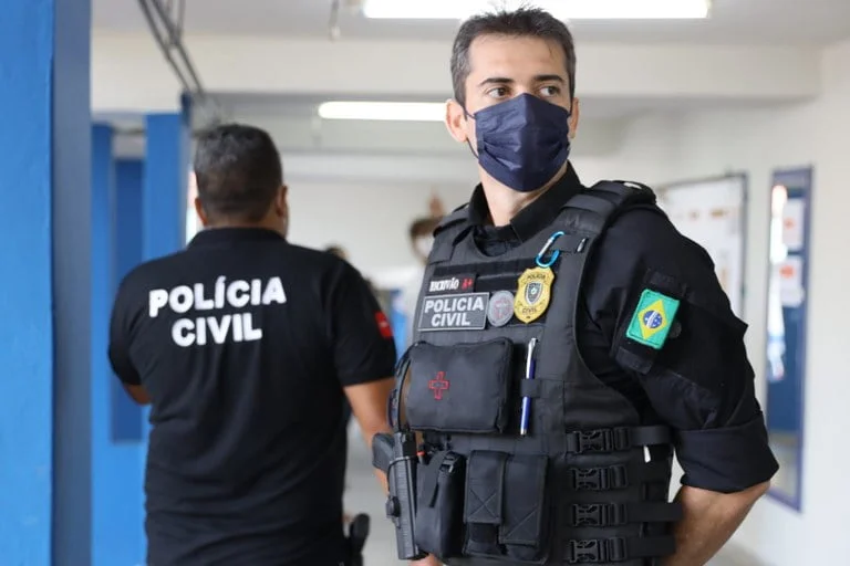 Policiais civis em ambiente interno, com uniforme completo, destacando a preparação para o concurso PC MS.