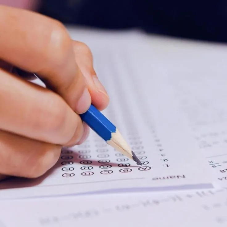 Pessoa preenchendo formulário de múltipla escolha, representando o processo seletivo para o concurso ITA.