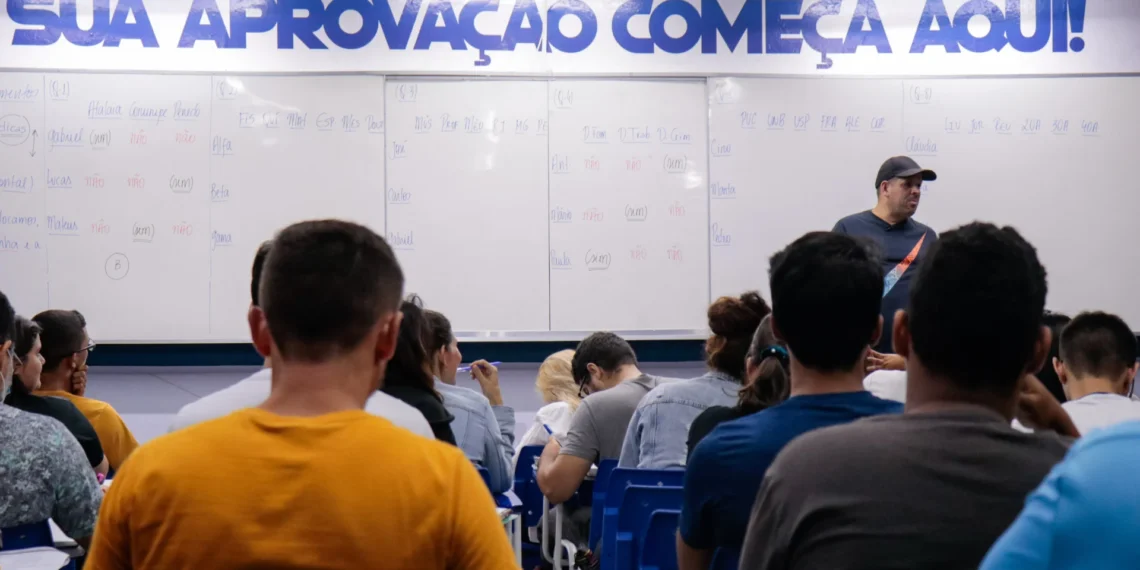 ala de aula com alunos atentos e professor explicando, com a frase 'Sua Aprovação Começa Aqui!' no quadro.