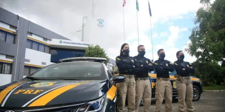 magem de policiais rodoviários federais em frente a um veículo oficial, simbolizando a carreira e os desafios da profissão.