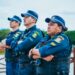 Três guardas municipais em uniforme, com braços cruzados, vigilantes e atentos em área pública. Seja você um também com o concurso Guarda Municipal.