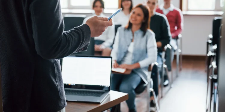 Grupo de pessoas participando de uma conferência de negócios em uma sala de aula moderna, ilustrando o programa de cursos técnicos gratuitos da Vale e Senai com bolsa de R$ 2.120.