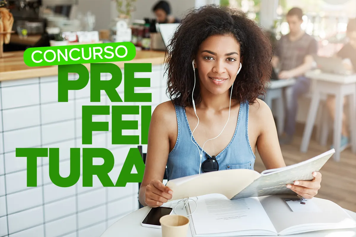 Jovem estudando em cafeteria com fones de ouvido, preparando-se para concursos públicos de prefeitura