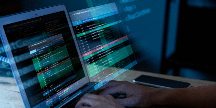 Programador trabalhando em código em dois monitores, representando a área de TI e a crescente demanda por especialistas no setor público, referindo-se aos concursos de TI que estão em alta.