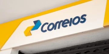 Fachada de agência dos Correios com o logotipo da empresa em amarelo e azul.