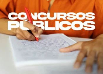 Pessoa estudando e anotando em caderno com caneta vermelha, ilustrando a preparação para o concurso da Secretaria de Educação com 2.300 vagas anunciado pelo governador.
