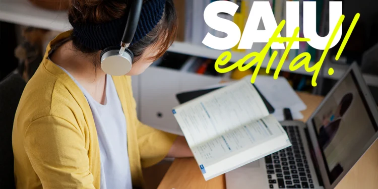 Mulher jovem estudando com fones de ouvido, anotando em caderno e usando laptop em ambiente de estudo.