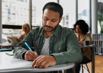 Estudante focado consultando informações importantes para sua prova do PND em sala de aula