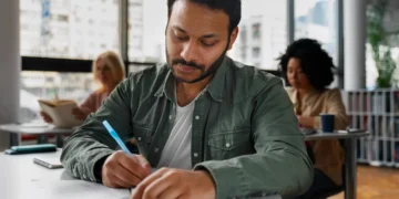 Estudante focado consultando informações importantes para sua prova do PND em sala de aula
