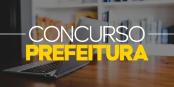 Imagem de um notebook com tela escrita "Concurso Prefeitura" e fundo de escritório em foco, simbolizando preparação para concursos.