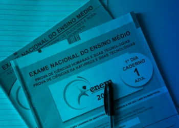 Caderno de questões "1º Dia, Caderno 1, AZUL" do Exame Nacional do Ensino Médio (ENEM) e uma caneta esferográfica preta em destaque, em tonalidade azulada.