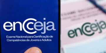 Aplicativo Encceja (Exame Nacional para Certificação de Competências de Jovens e Adultos) em tela de smartphone, com a inscrição oficial sobreposta ao logo em um fundo azul-escuro.