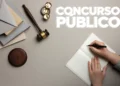 Imagem ilustrativa de um concurso público com martelo de juiz e documentos sobre uma mesa.