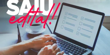 Pessoa digitando em notebook com tela de checklist; mensagem “Saiu edital!”