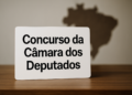 Placa com os dizeres 'Concurso da Câmara dos Deputados' sobre uma mesa.