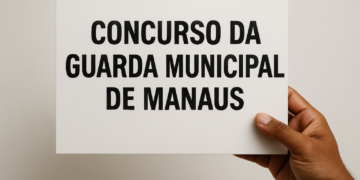 Pessoa segurando placa escrita Concurso da Guarda Municipal de Manaus.