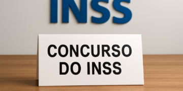 Placa com os dizeres 'Concurso do INSS' sobre uma mesa.