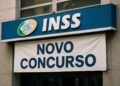 Fachada do INSS com faixa anunciando novo concurso devido a mais de 23 mil cargos vagos em 2026