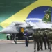 Militares em formação diante de aeronave da Aeronáutica com bandeira do Brasil ao fundo, representando novo edital autorizado com 489 vagas.