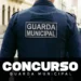 Agente da Guarda Municipal caminha em rua de paralelepípedo com uniforme oficial