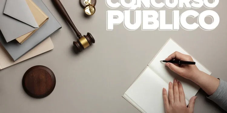 Martelo de juiz e mãos escrevendo em caderno com texto Concurso Público representando concurso da Câmara de Domingos Martins ES