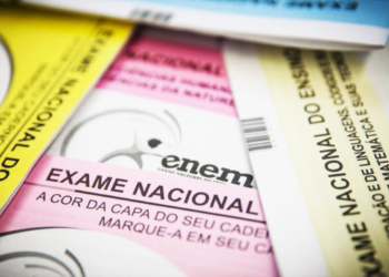 Cadernos de provas coloridos do Enem sobre mesa — Enem ganha novo papel e avaliará nível da educação nacional