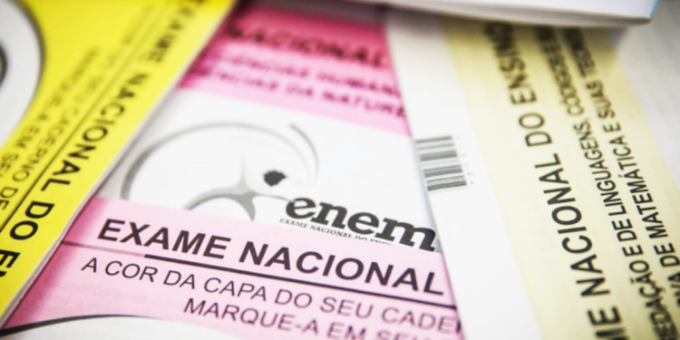 Cadernos de provas coloridos do Enem sobre mesa — Enem ganha novo papel e avaliará nível da educação nacional