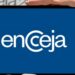 Pessoa segurando um tablet que mostra o logotipo do Encceja em branco sobre fundo azul, com folhas impressas da prova de redação desfocadas ao fundo.