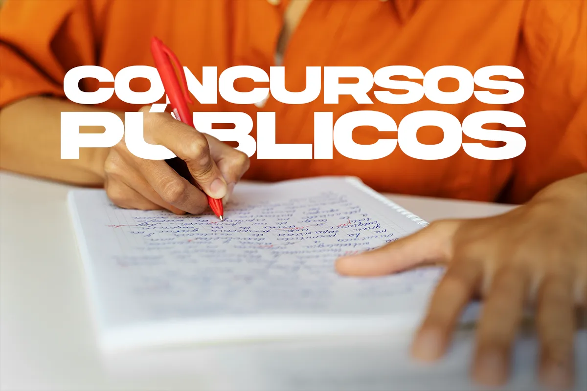 Ano eleitoral 2026 – O que muda na prática para o concurseiro Pessoa de camisa laranja escrevendo em caderno com caneta vermelha