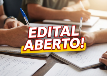 Mãos de pessoas escrevendo em cadernos com canetas sobre mesa de madeira e texto "EDITAL ABERTO!" em destaque