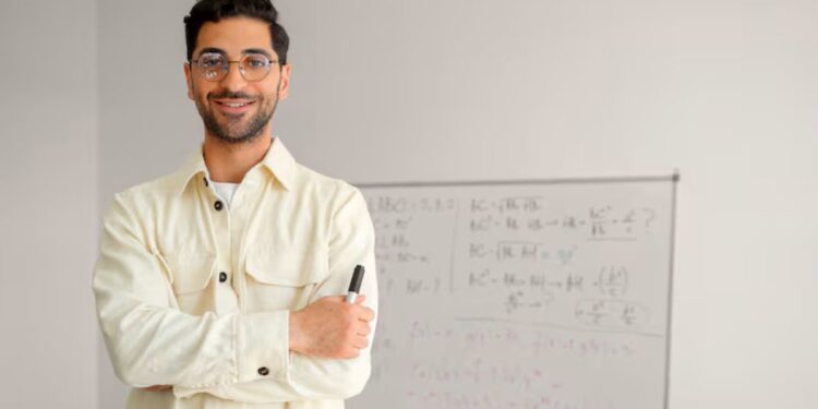 Professor em sala de aula com quadro ao fundo