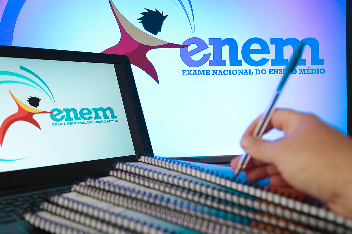 Dicas Enem 2026 Logo do ENEM com figura estilizada, cadernos empilhados e mão segurando caneta azul em ambiente de estudos