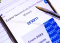 Tela do portal gov.br com página do Exame Nacional do Ensino Médio (ENEM) , caneta e material azul com logo do ENEM