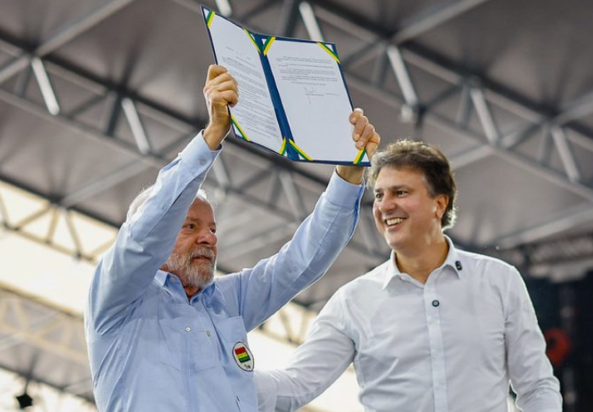 Quem é beneficiado com o decreto no Prouni? Dois homens segurando documento oficial com as cores do Brasil erguido em evento público
